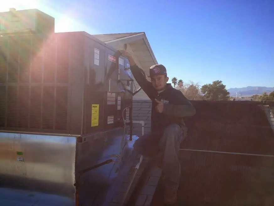HVAC technician performing HVAC Inspection on a rooftop unit in Waunakee
